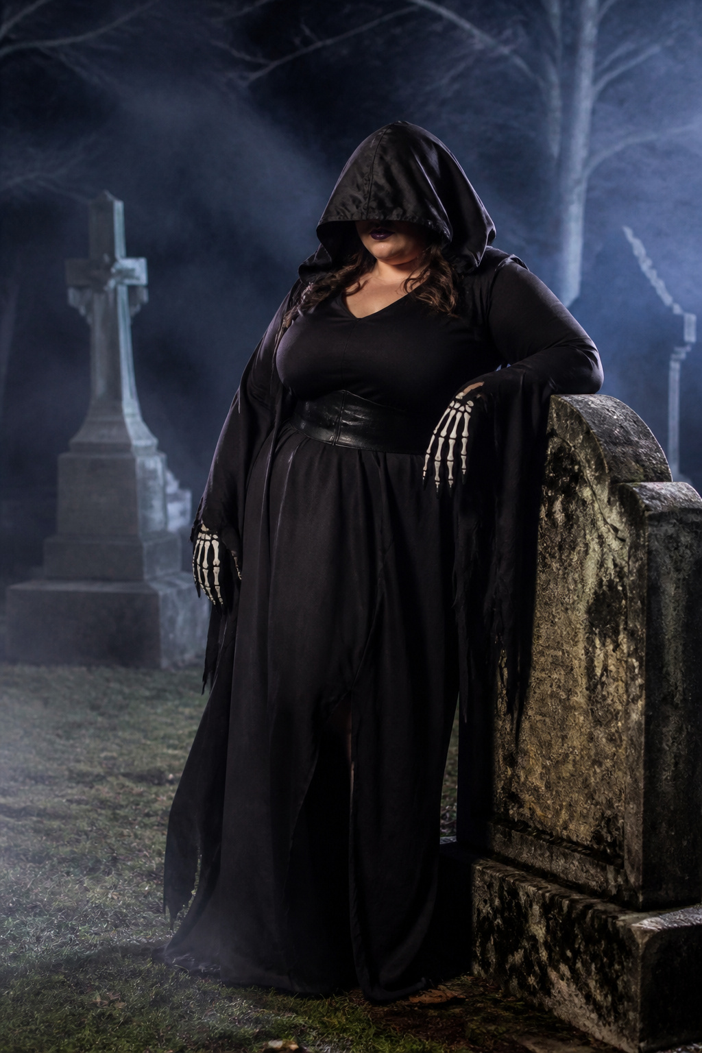 Plus-size model in a Dark Reaper costume surrounded by headstones.