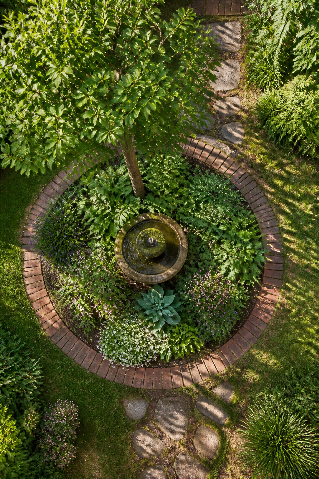 23 Brick and Rock Edging Ideas for Garden Borders (2026) 6 Circle of bricks pressed into the ground around a tree.
