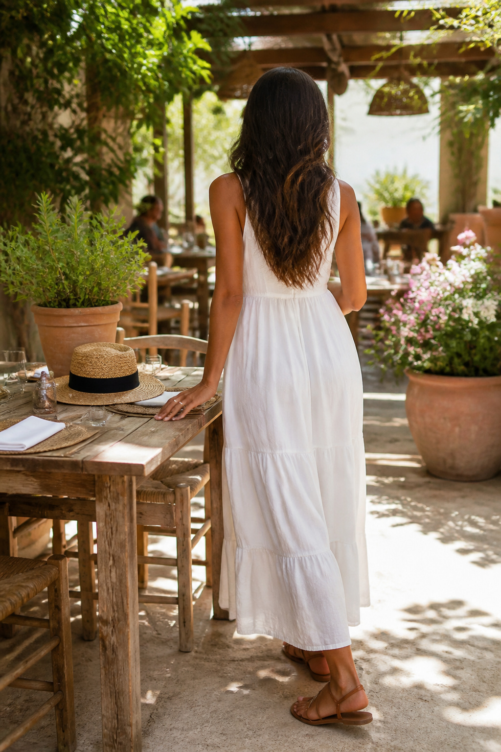 A sleeveless dress paired with sandals in an outdoor dining setup.