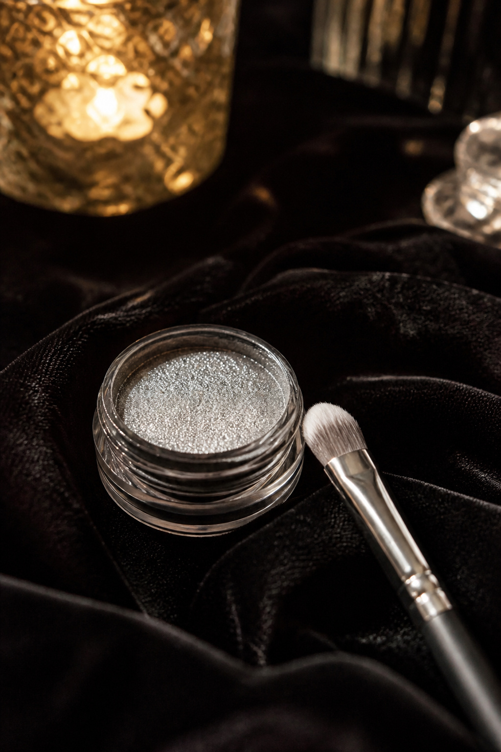 Metallic silver eyeshadow in a jar set against black velvet.