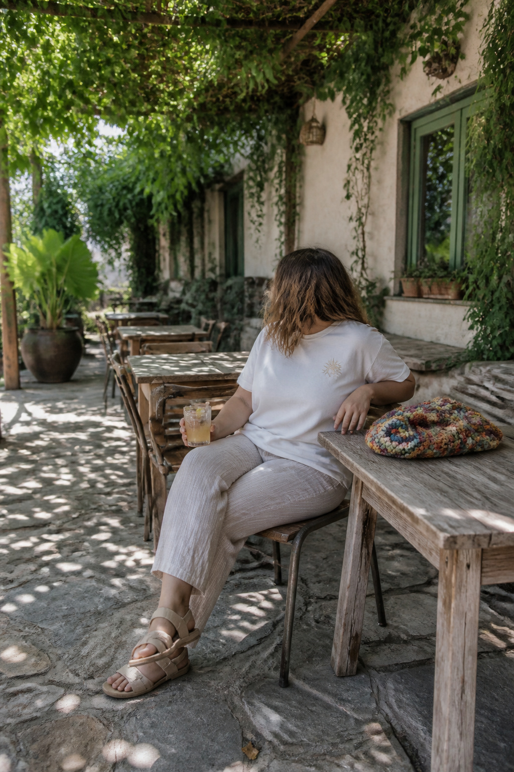 A graphic tee paired with ankle-length linen pants and sandals.