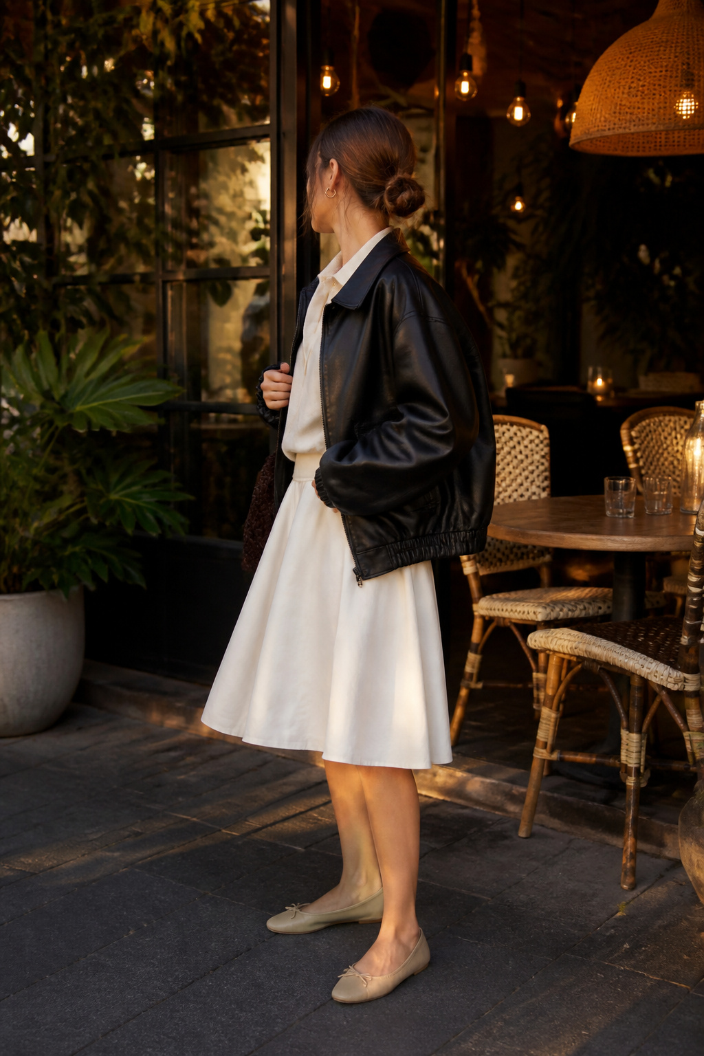 An oversized leather bomber jacket with a polo sweatshirt and white skirt.