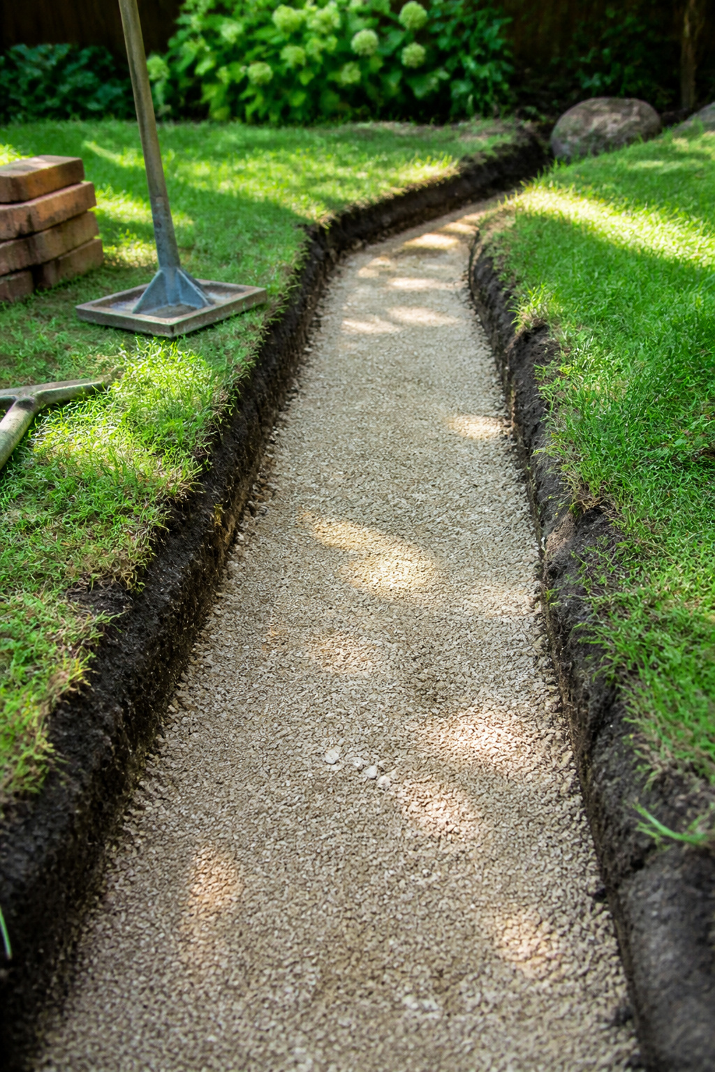 A trench filled with compacted paver base material.