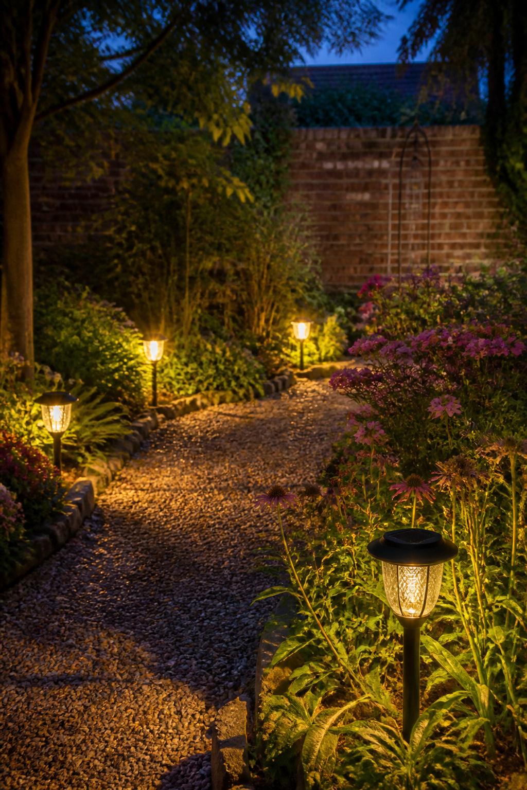 Pathway lights along a gravel path in a garden.