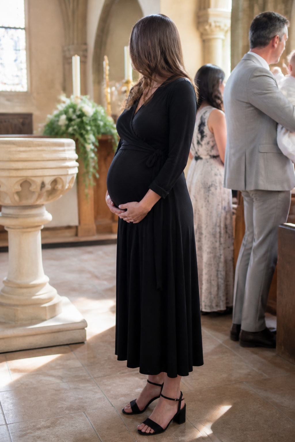 Maternity Dresses: Styles for Every Stage and Occasion 16 Expectant mother in a nursing dress at a christening ceremony.
