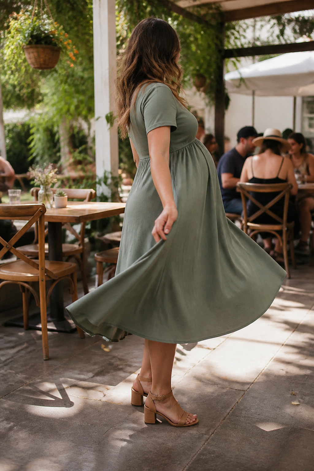 Maternity Dresses: Styles for Every Stage and Occasion 4 Expectant mother wearing a midi-length dress at a café patio.