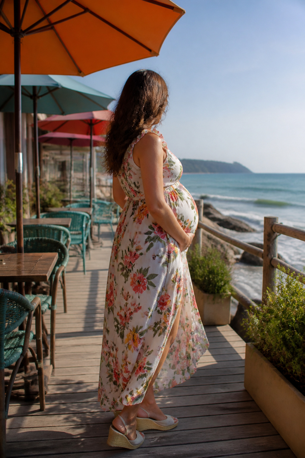 Maternity Dresses: Styles for Every Stage and Occasion 8 Expectant woman in a sleeveless floral maternity dress by the beach.