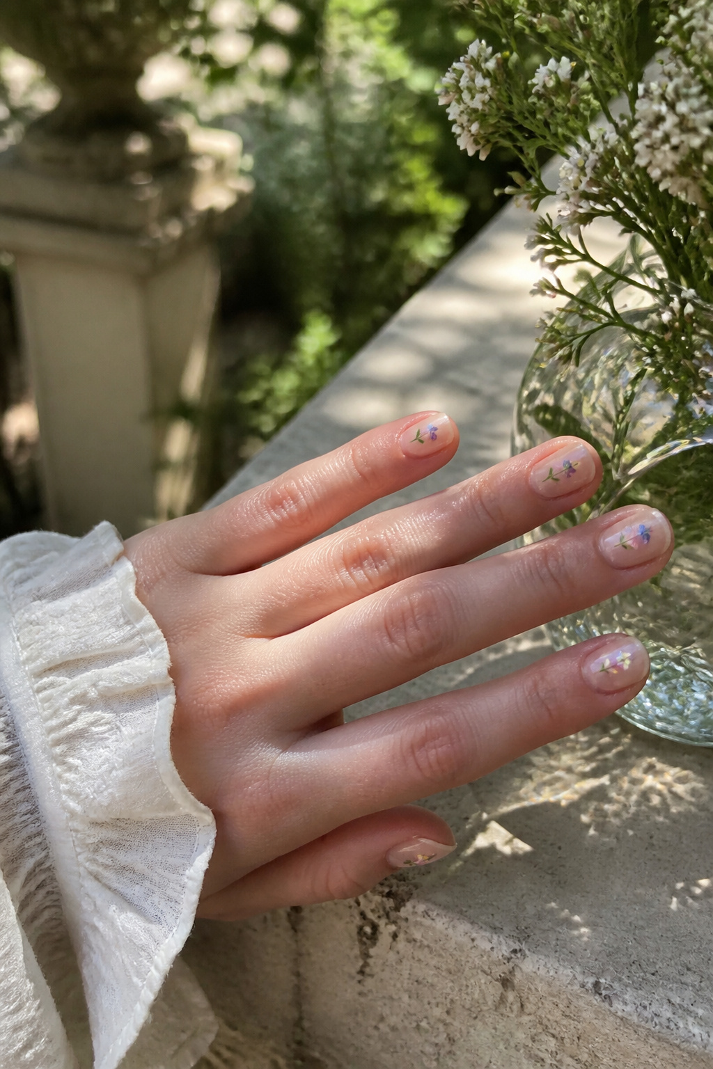 25 Short Nail Ideas for 2026: Designs You Can Actually Try 3 Short nails featuring tiny pastel flowers on a beige base.