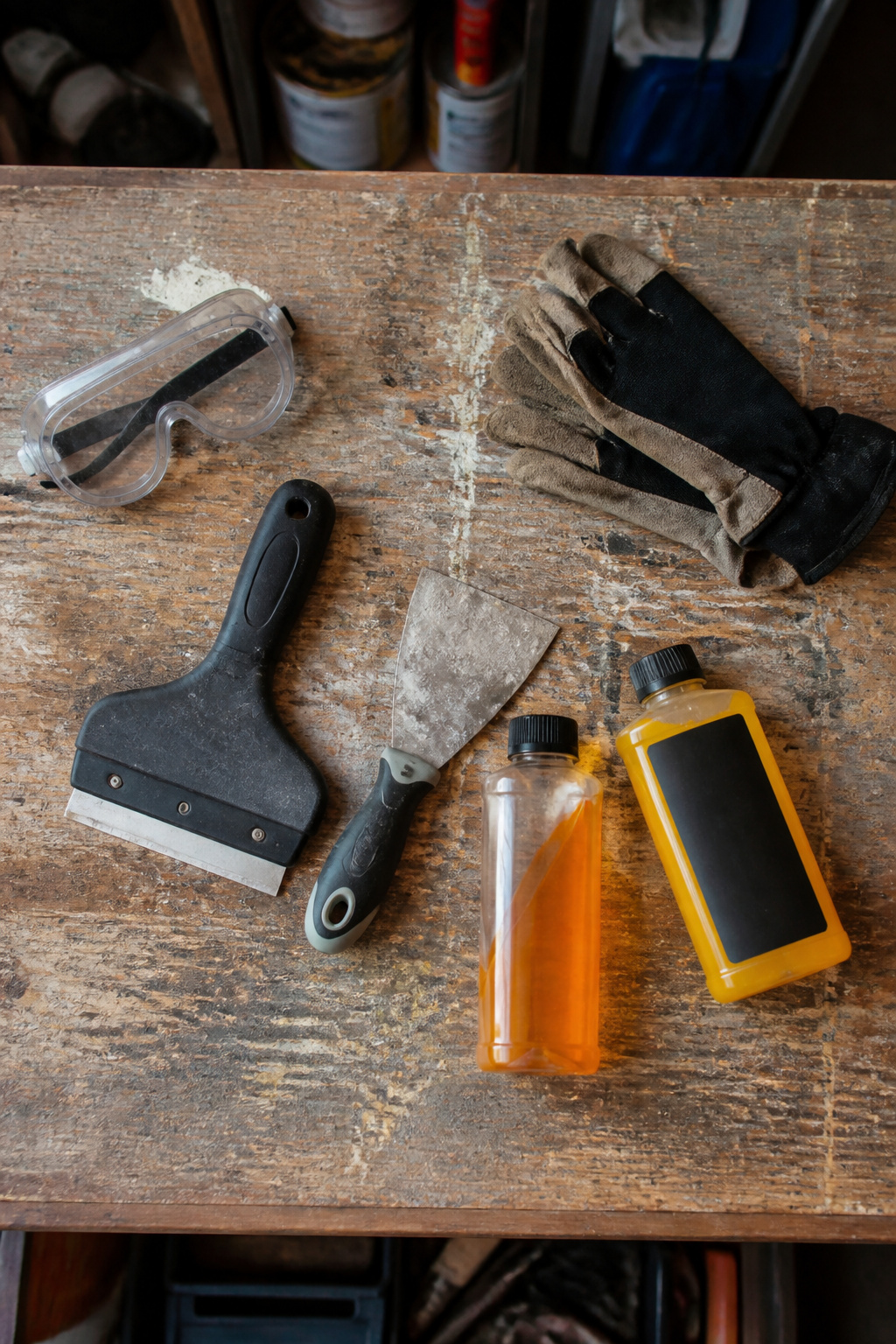Tools for removing carpet glue including scrapers and a floor sander.