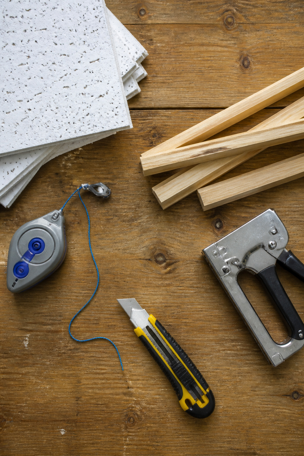 Tools and materials needed for installing ceiling tiles.