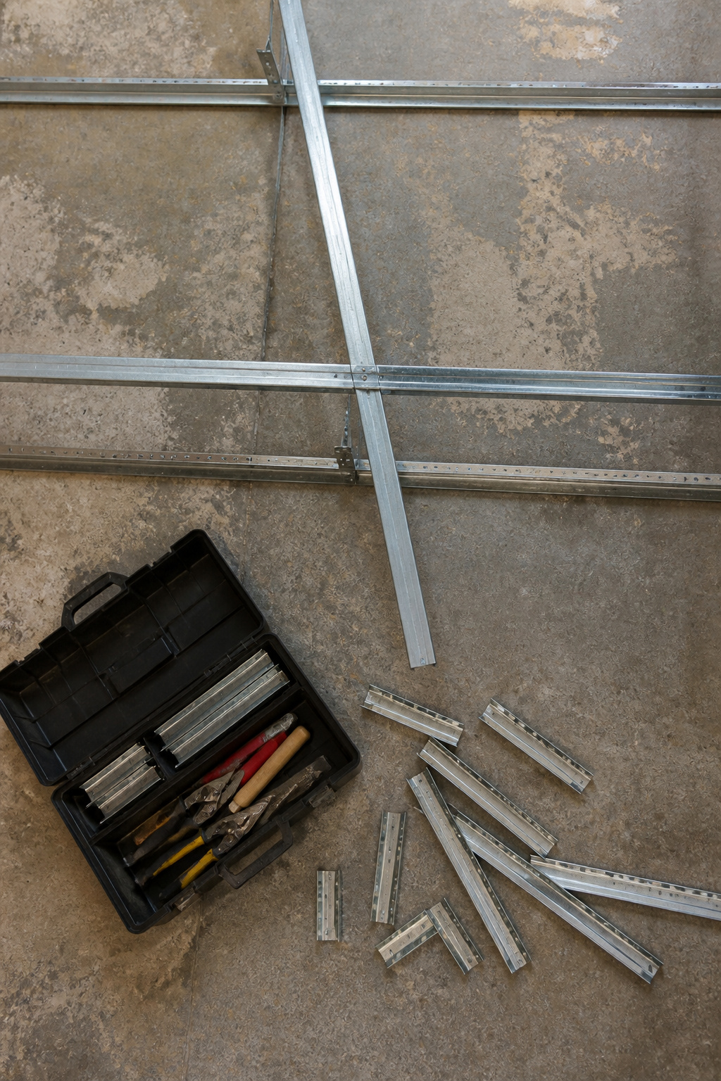 Cross tees locking into main runners in a ceiling grid.