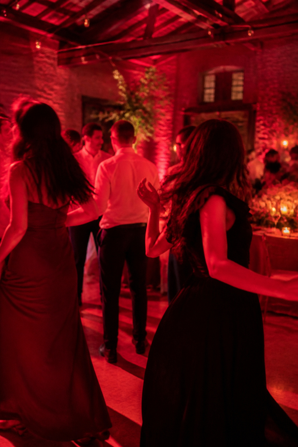 Dance floor illuminated with red lighting during a wedding.