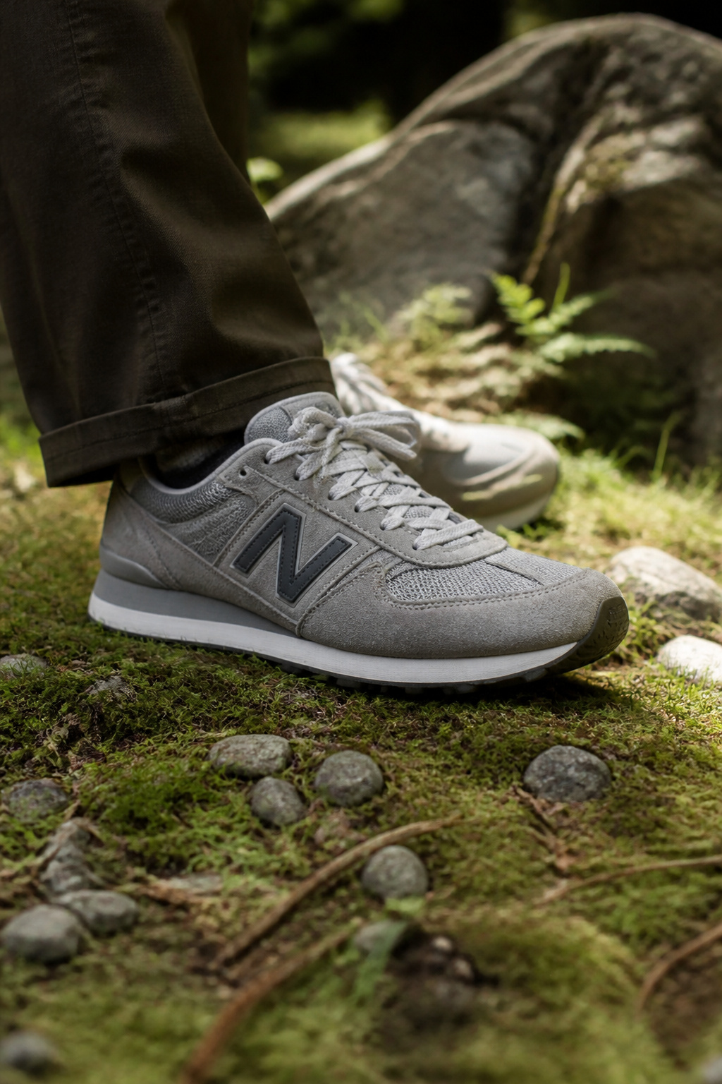 Close-up of New Balance 574 sneakers against rugged outdoor elements.