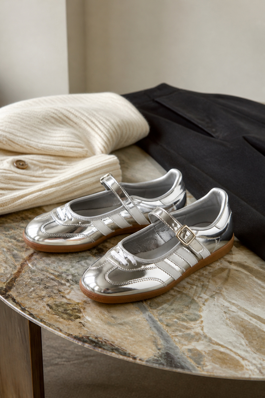 Silver Samba Jane shoes reflecting light on a simple background.