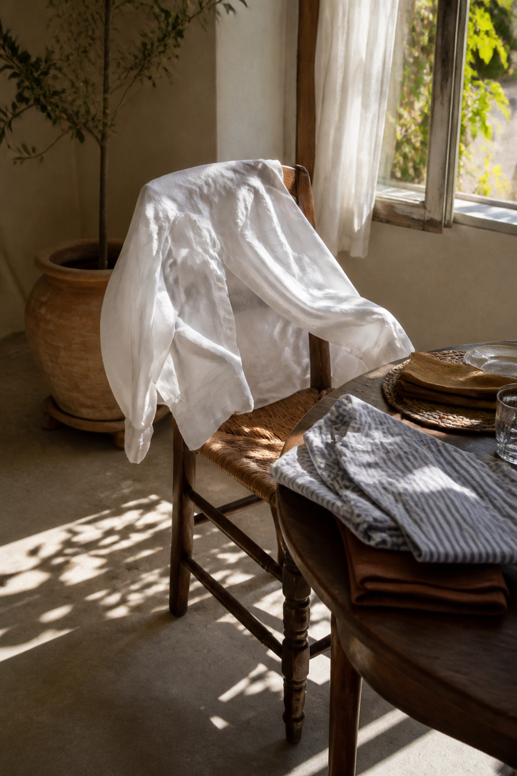 A white poplin shirt draped over a vintage chair.