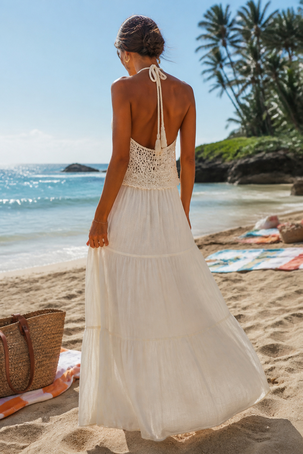 A woman in a halter maxi dress with a layered crochet top.