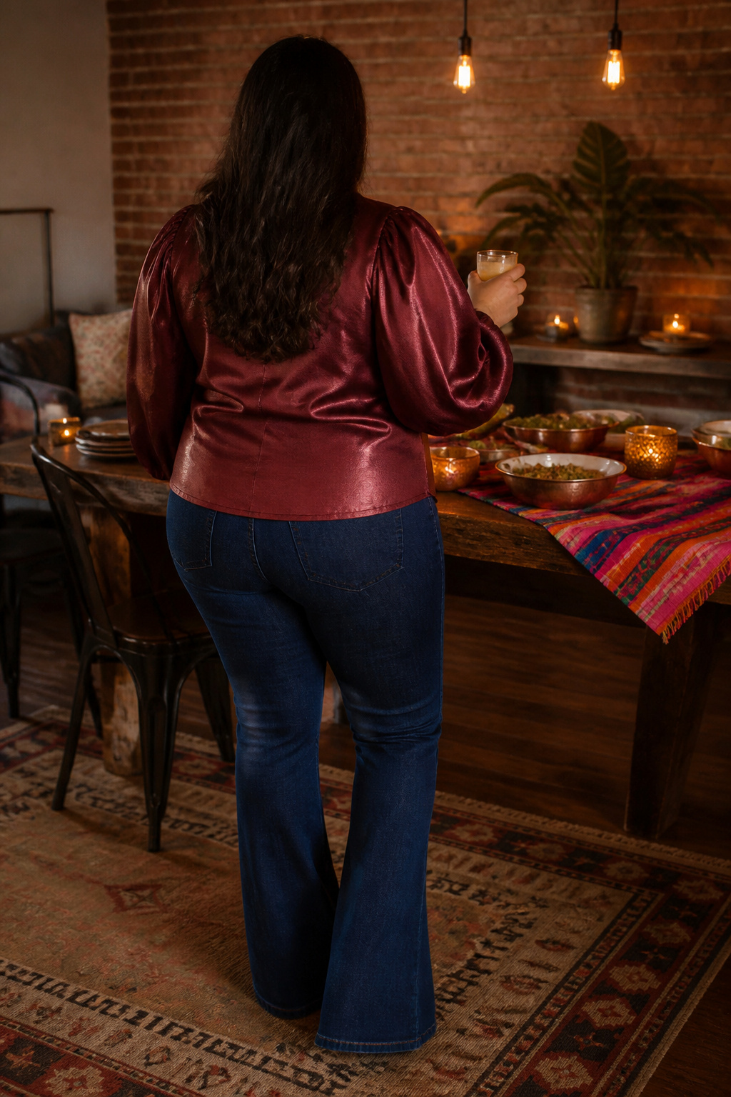 A festive top with volume sleeves and flare jeans at a dinner table.