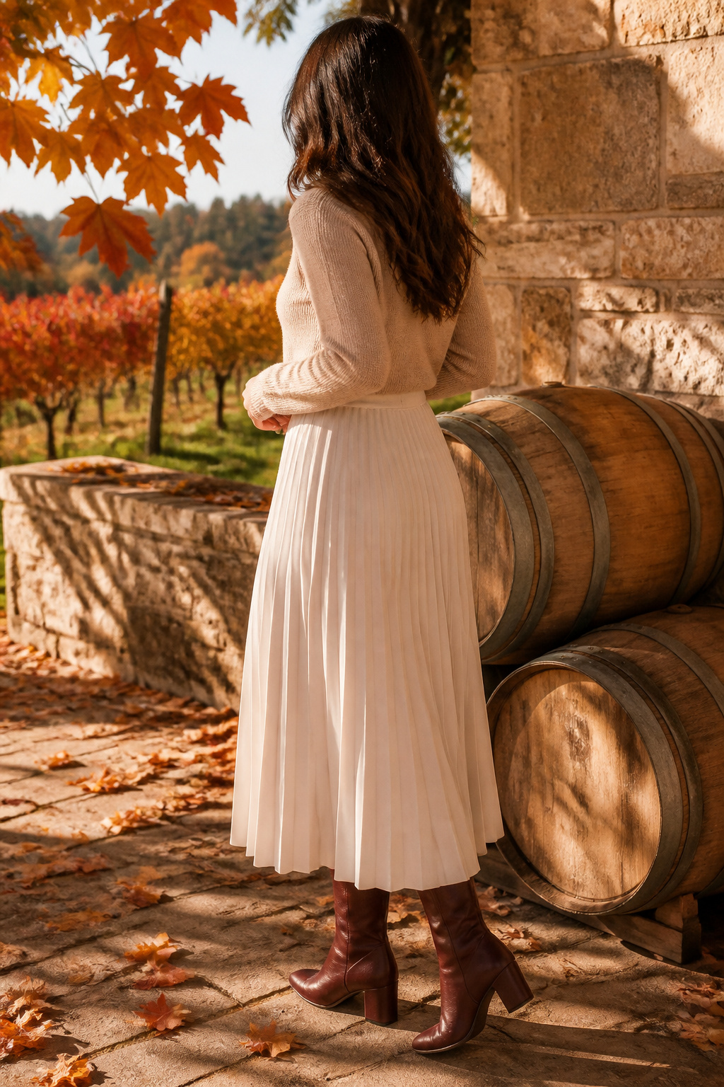 Cream pleated midi skirt with a beige knit top tucked in.