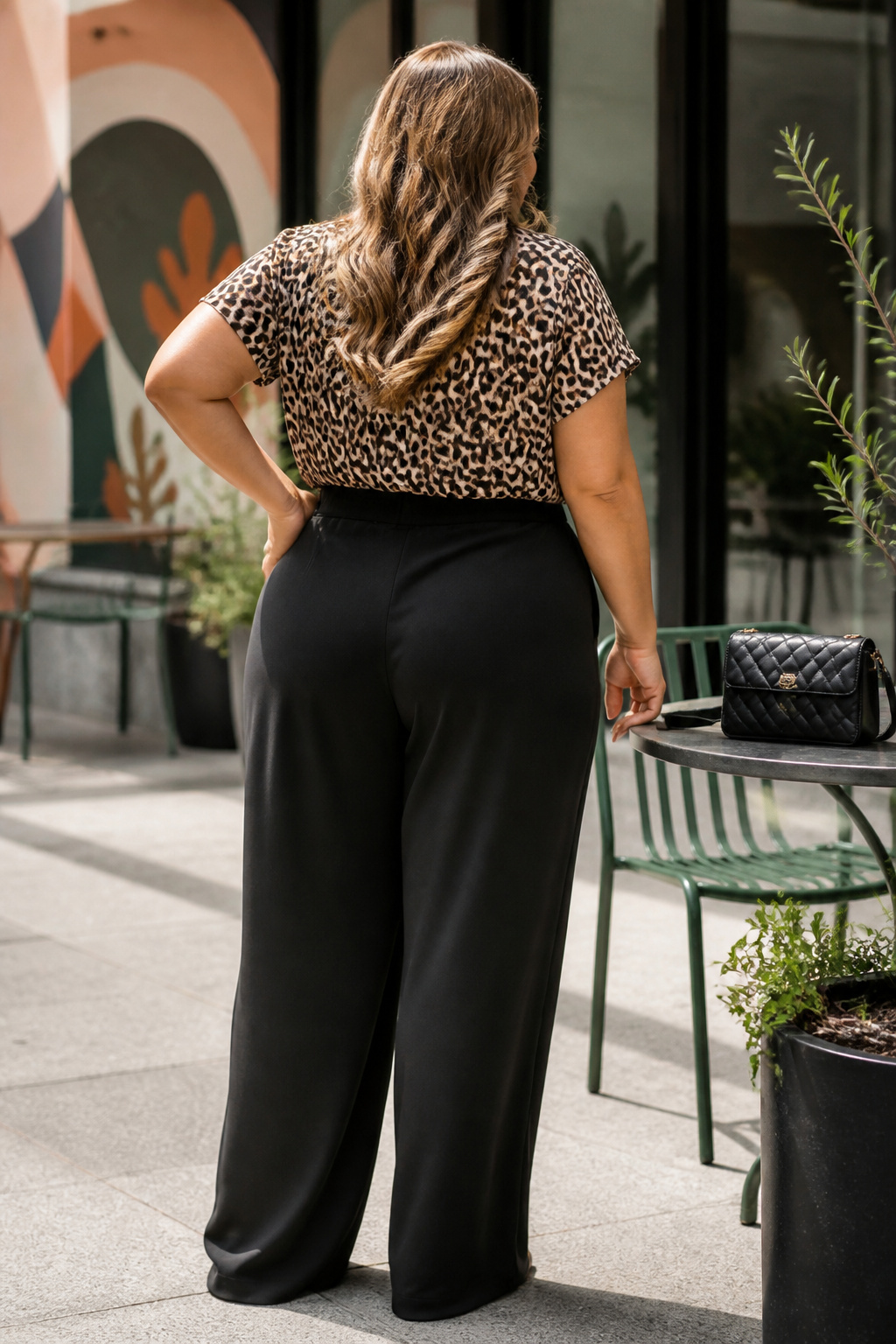 Leopard print top styled with high-waisted black trousers.