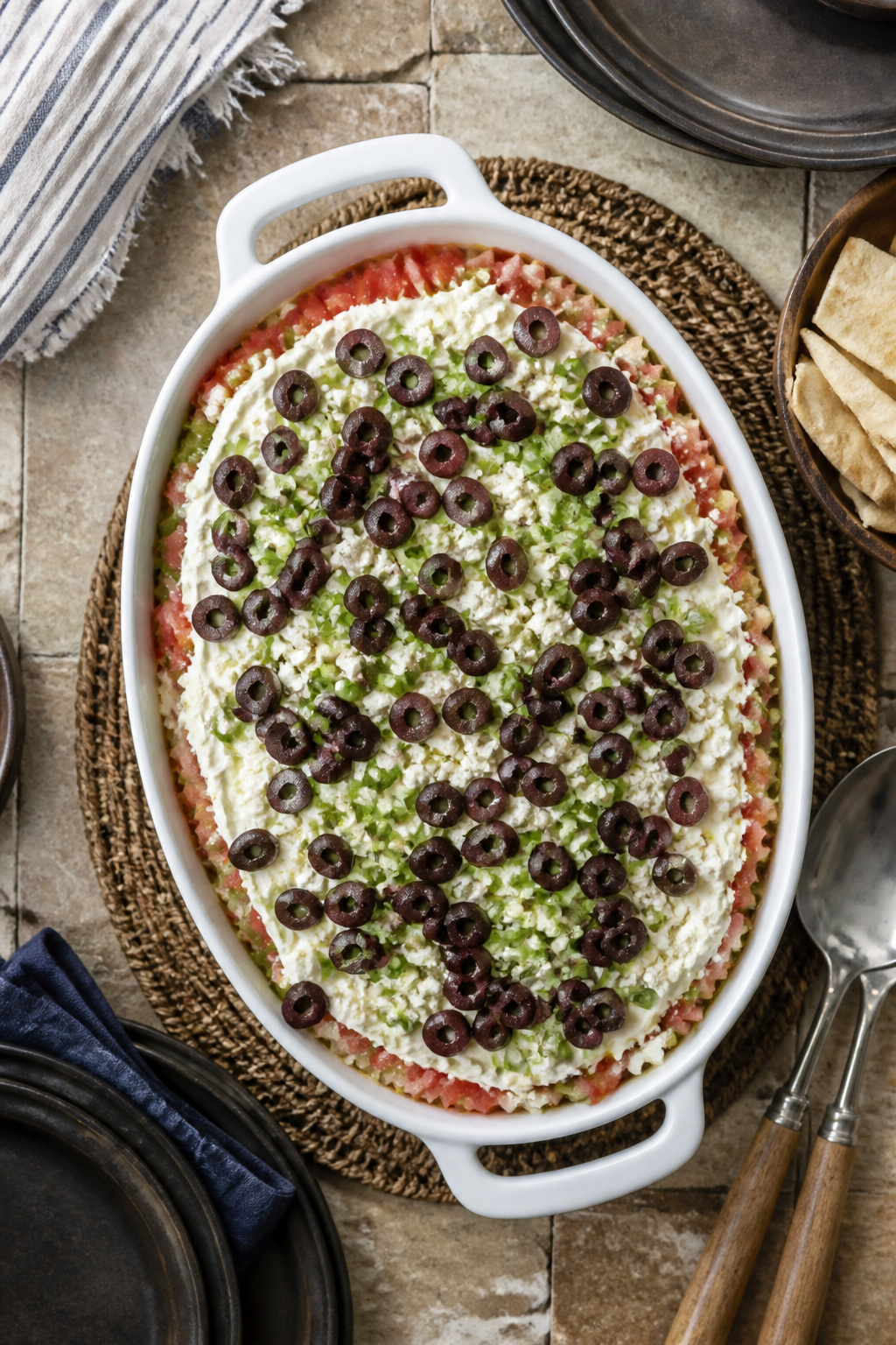 Sliced Kalamata olives and green onions layered on top of the dip.