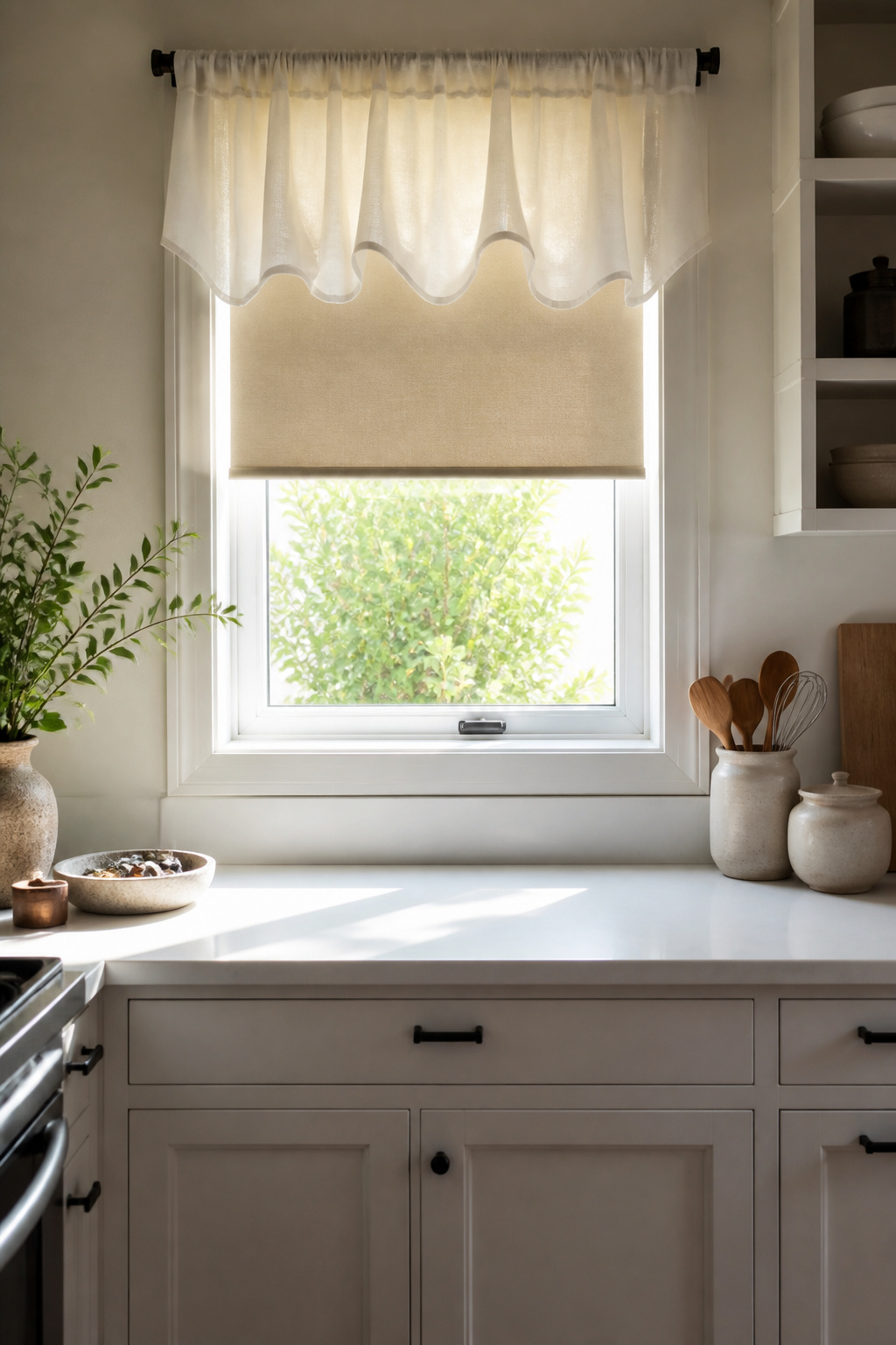 A voile valance adorns a small window above a roller blind.