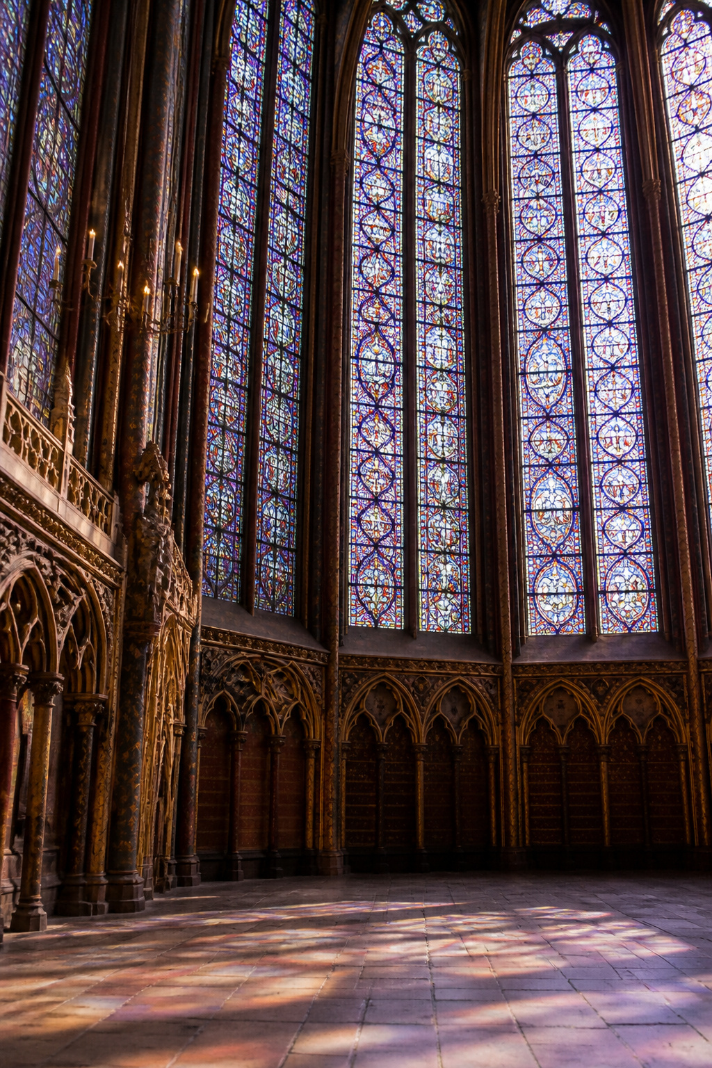Fifteen stained glass windows in a Gothic chapel filled with biblical scenes.