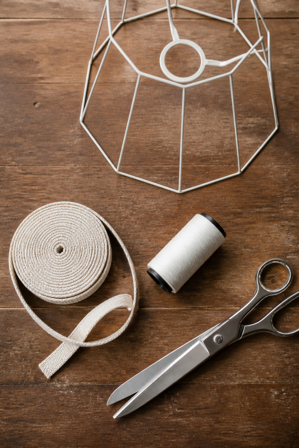 Cotton tape, scissors, thread, and clips laid out for lamp shade construction.