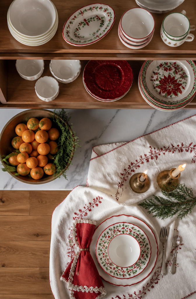 Christmas plates and bowls displayed on kitchen shelves.