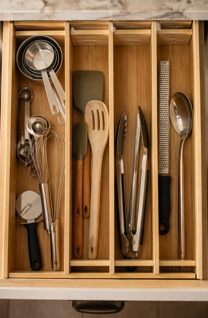Utensil drawer with adjustable dividers for organization.