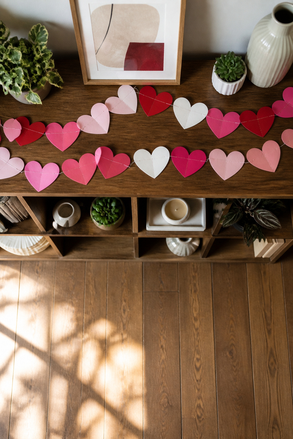 10 Simple Valentine Decorations Ideas for 2026 5 Colorful paper heart garlands displayed across a shelf.