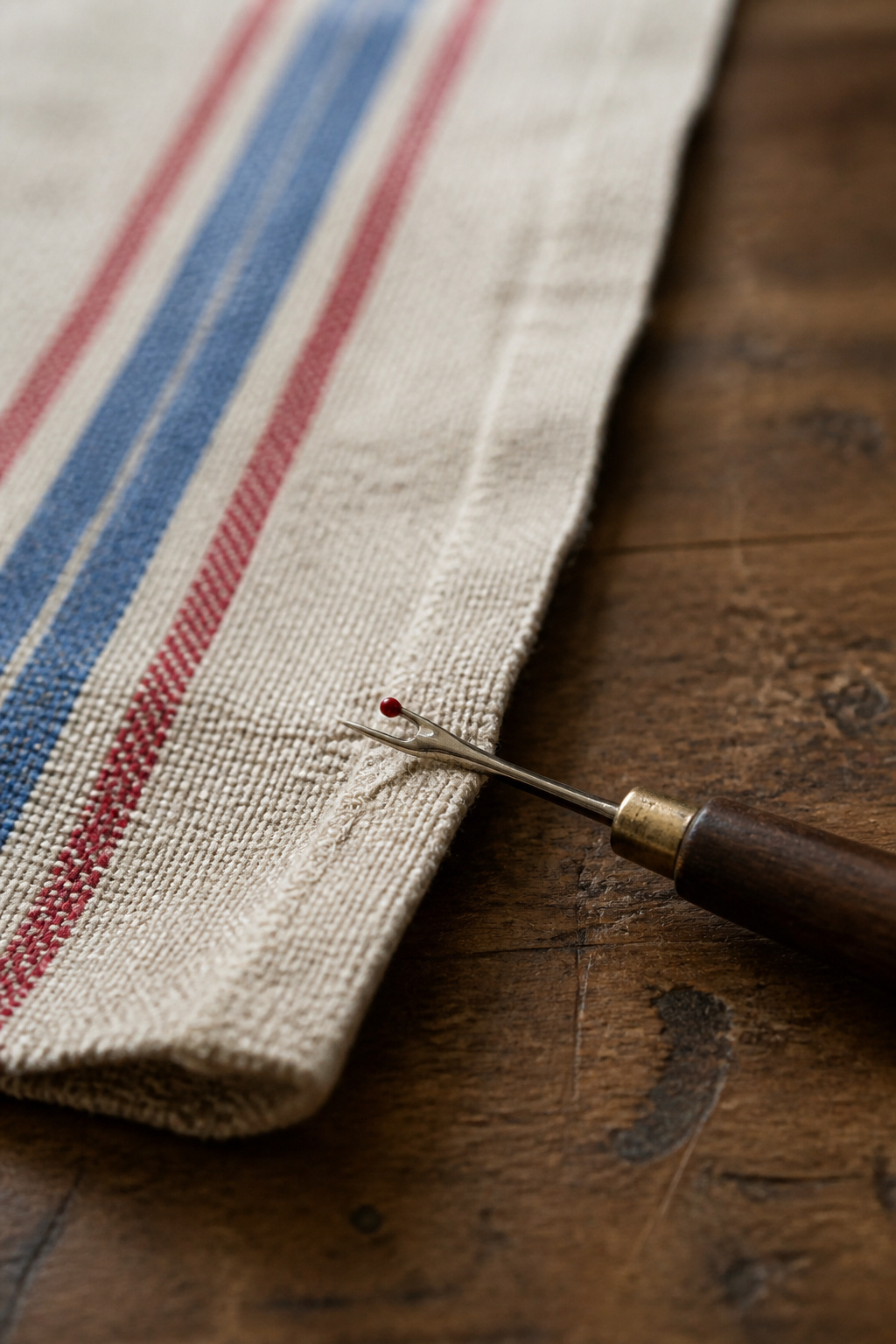 Vintage Grain Sack Table Runner: Methods, Materials and Sources 10 A seam ripper positioned to lift a stitch on a grain sack seam.
