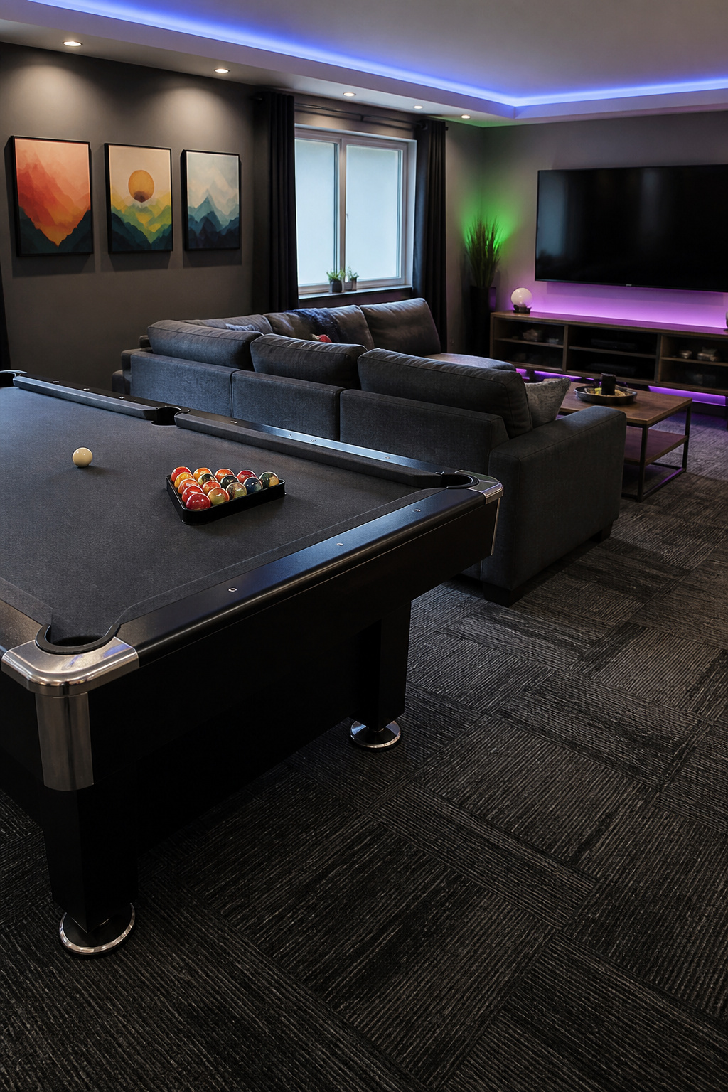 A game room with a pool table, sectional couch, and entertainment area.