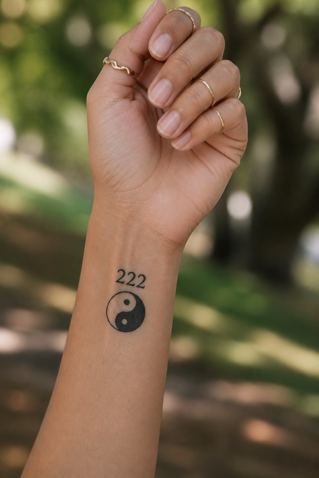 A tattoo featuring the yin yang symbol alongside the numerals '222'.
