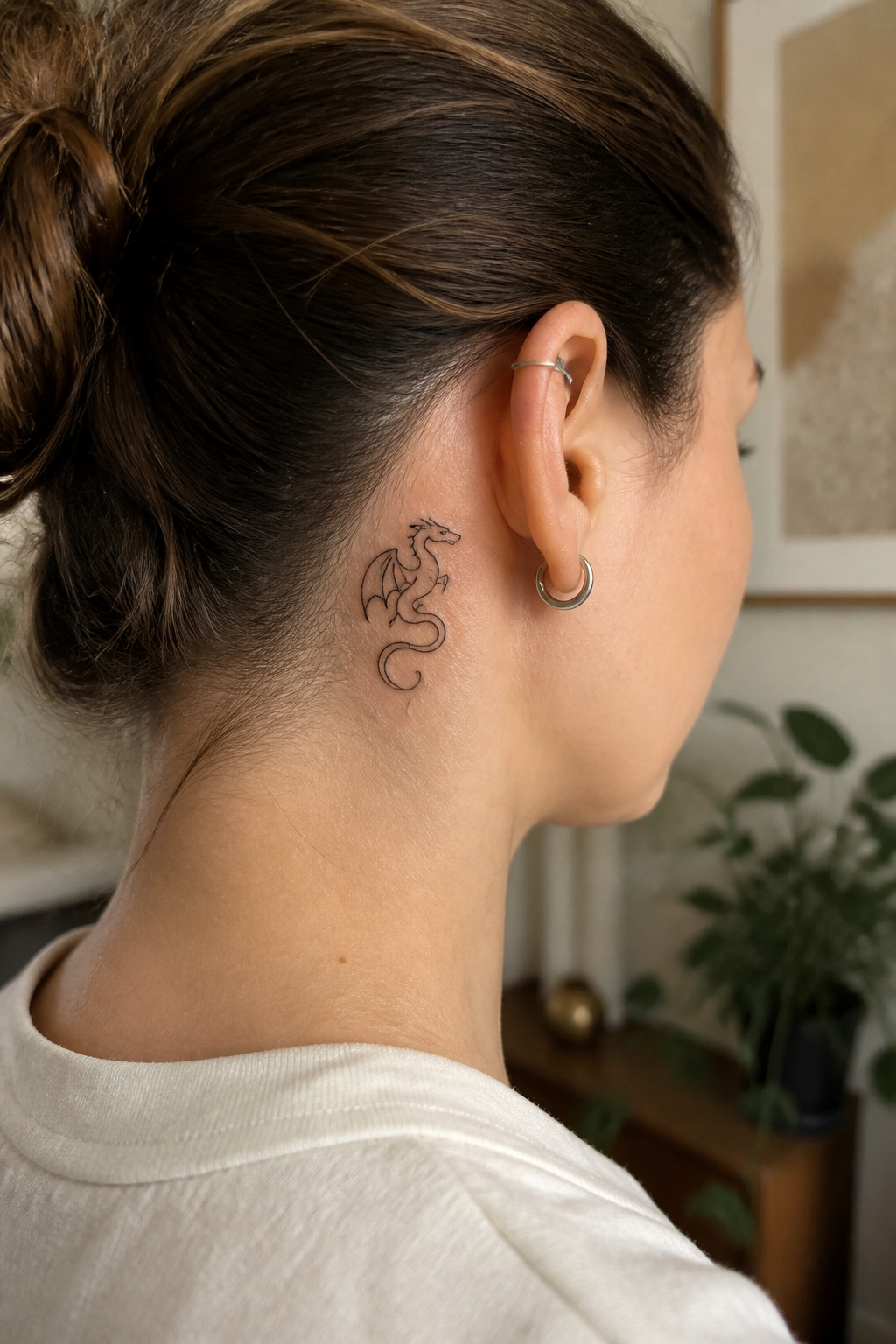 Close-up of a minimalist dragon tattoo behind the ear.