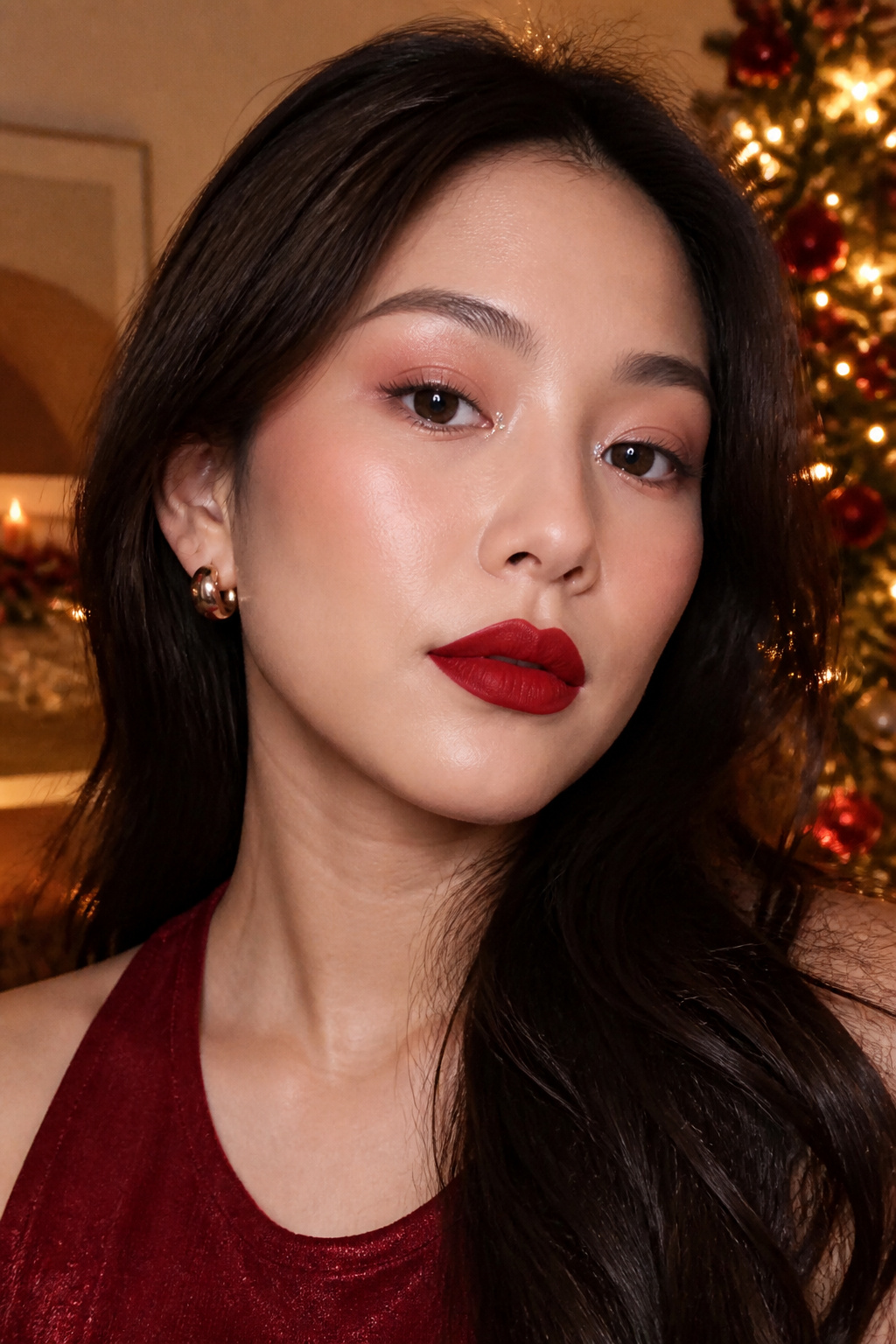Close-up of a model's makeup featuring a red lip and soft pink eyeshadow.