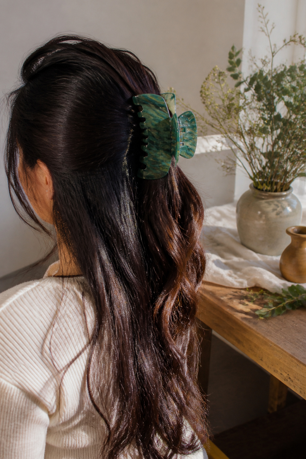 Cute Hair Accessories: Styles, Materials and How to Wear Them 1 A large green malachite claw clip in dark hair styled half-up.