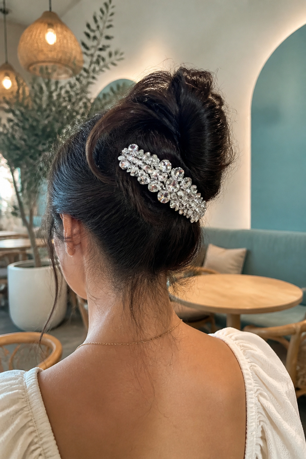 Cute Hair Accessories: Styles, Materials and How to Wear Them 4 A crystal-studded barrette gleaming in a high bun hairstyle.