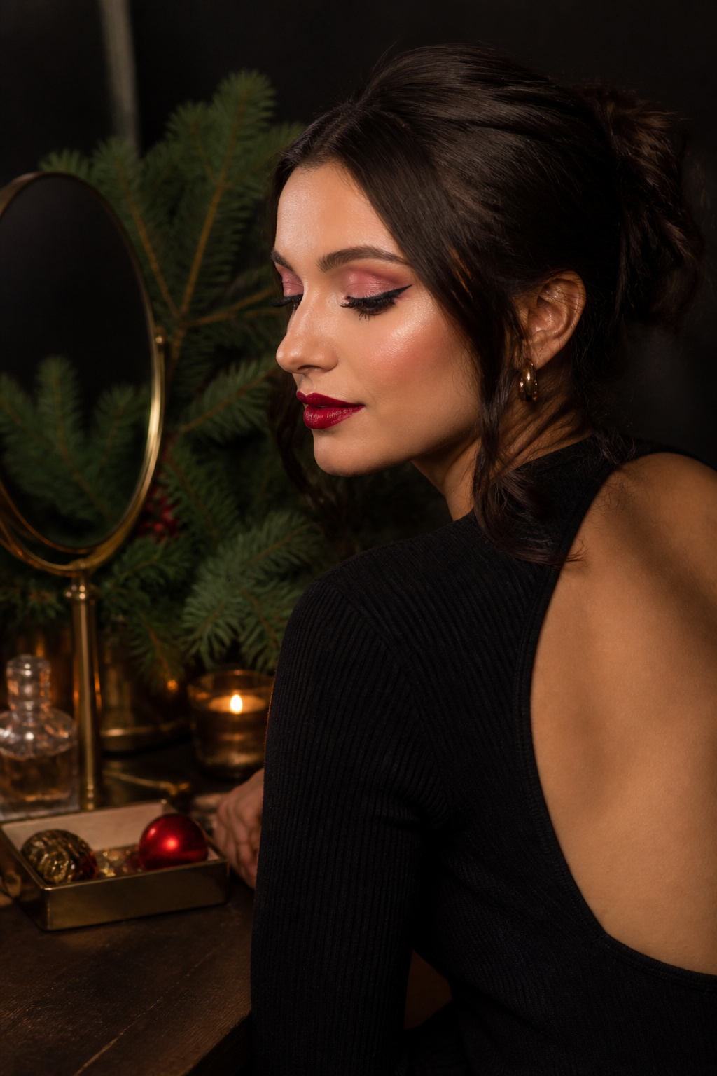 Model with red lipstick and black winged eyeliner against a dark backdrop.