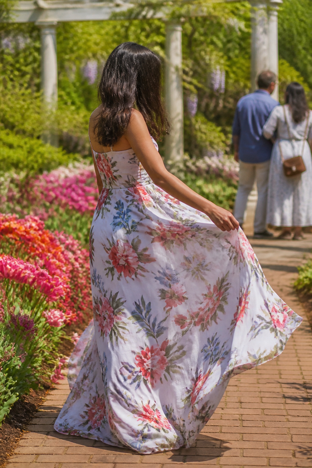 34 Spring Outfits to Copy for Warmer Weather in 2026 33 Model in a floral dress among blooming garden plants.