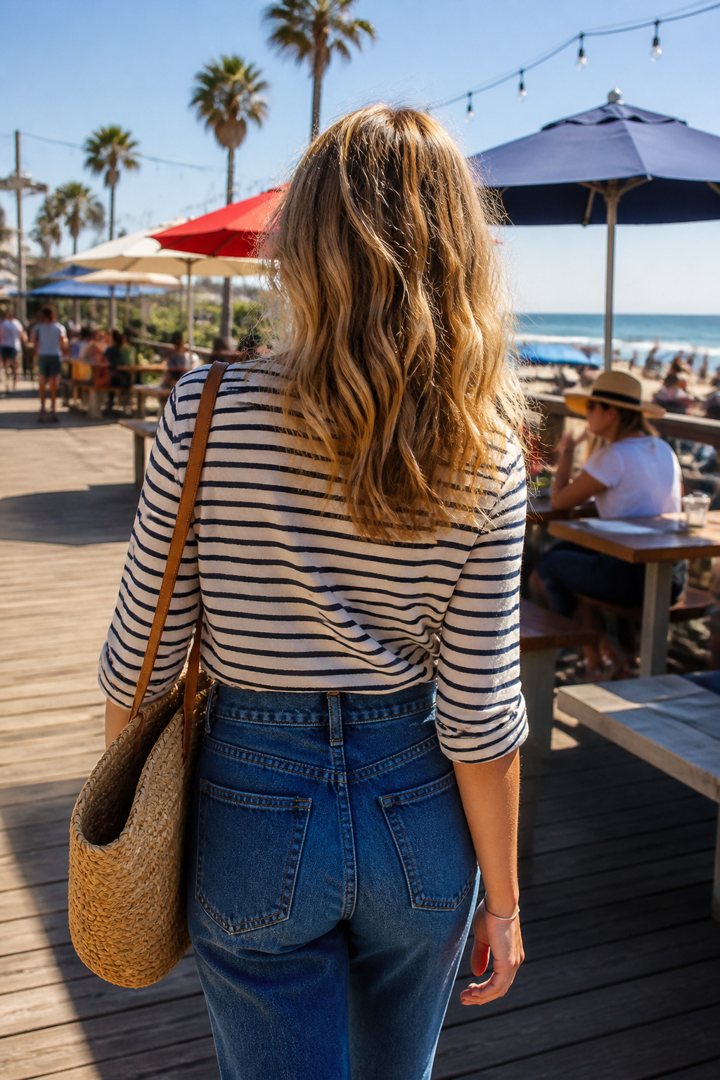 34 Spring Outfits to Copy for Warmer Weather in 2026 34 Model wearing a striped top with high-waisted jeans at a coastal boardwalk.