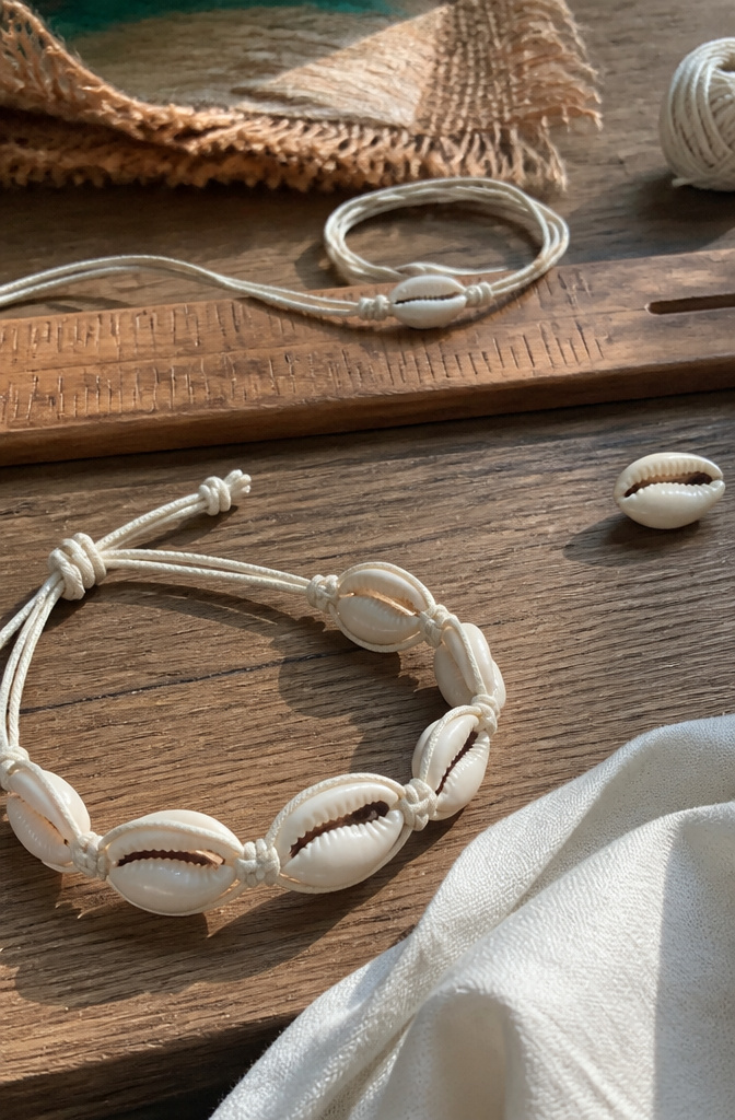 Shell Bracelet DIY: String, Drill or Glue Shells in 6 Steps 3 Knots around a cowrie shell on a rustic wooden surface.